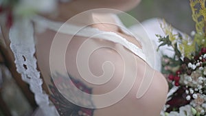 Bride with a tattoo on her back and holding flowers