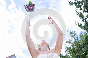 Bride throwing flower bouquet at wedding