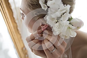 Bride to put the earrings while looking in the mirror