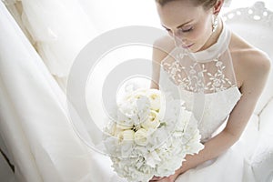 Bride to sit on the sofa has a bouquet