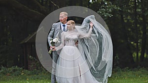 The bride tosses her veil next to her groom.