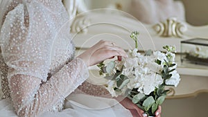 The bride touches the bouquet of flowers.
