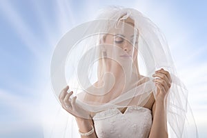 Bride with veil on the face looks at left