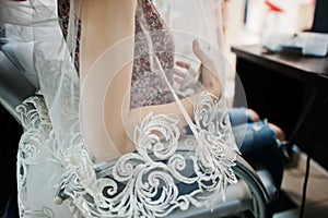 Bride with veil lace sitting at chair on beayty salon.