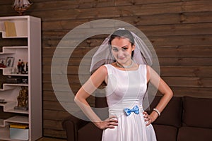 Bride in veil and white dress with blue bow posing