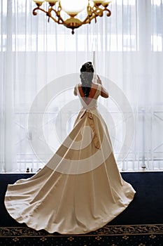 The bride is waiting for the groom by the window