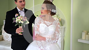 The bride is waiting for a loved one. Groom gives a bouquet to the bride.