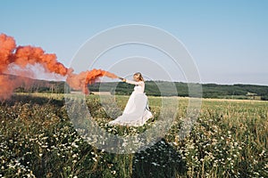 Bride walking outdoor on field with smoke grenade