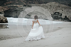 The bride walks alone on the beach