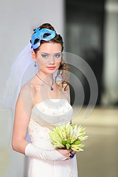 Bride wearing in dress with mask in hairdo