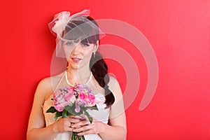 Bride wearing dress and short veil holds bouquet