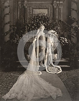 Bride wearing medieval gown standing at altar