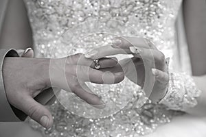 Bride is wearing a ring on the hand of the groom
