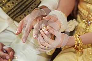 Bride wearing wedding ring for her groom hand