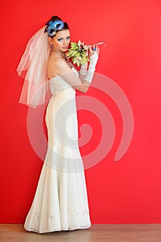 Bride wearing white dress with blue mask in hairdo