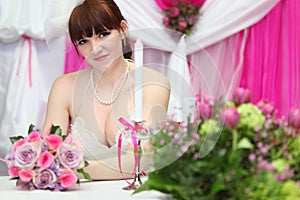 Bride wearing white dress sits at table