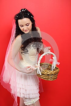 Bride wearing in white short dress holds basket photo