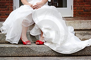 Bride wearing white wedding dress and red shoes