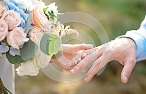 Bride wears groom a wedding ring Bride hand holds a beautiful wedding bouquet
