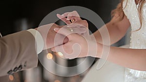 Bride wears ring on groom`s finger. The bride and groom exchange wedding rings.