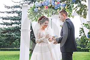 Bride wears a ring on the hand of the groom on wedding ceremony