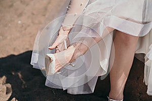 The bride wears shoes. The girl was tired of wearing shoes with heels. The woman takes her shoes off her feet.