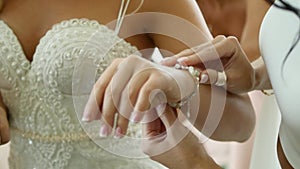 The bride wears wedding jewelry, put bracelet on wrist