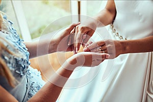 Bride on wedding day holding her mother`s hands. Concept of relationship between moms and daughters