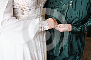 Bride on wedding day holding her mother`s hands. an old woman holds her young daughter married