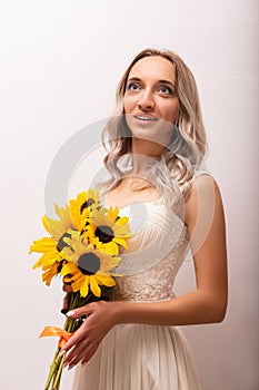 Bride in a wedding dress with a bouquet of sunflowers.Beautiful woman.Floristics