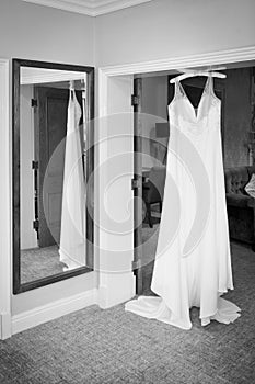 bride wedding dress hanging from a coat hanger