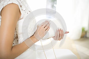 Bride in a wedding dress holds in hand a white bag. Beautiful manicure. Wedding day. Wedding rings