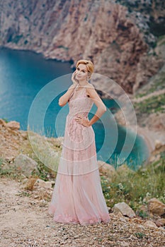 Bride in wedding dress standing on a rock