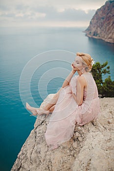 Bride in wedding dress standing on a rock