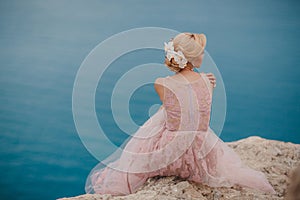 Bride in wedding dress standing on a rock