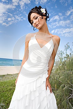 Bride in wedding gown on beach