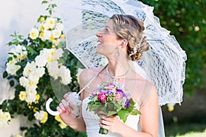 Bride at wedding with parasol in garden