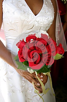 Bride with wedding rings in red bouquet