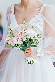 The bride in a white dress holds the bride& x27;s bouquet