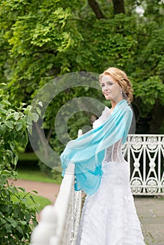 Bride in white dress on wedding day outdoor. Geen leafs background