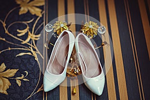 Bride white high heels holding from an ancient striped wall