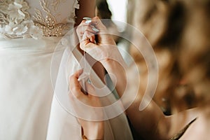 Bride white lace wedding dress. Bride help put on the wedding dress
