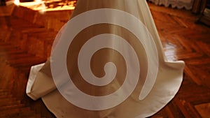 bride in white silk wedding dress and long veil moves away from camera.