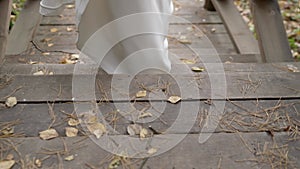 A bride in a white wedding dress walks through the autumn forest. Close-up of the bride's feet in shoes, autumn