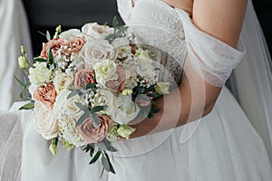 Bride& x27;s bouquet close up, the bouquet consists of pink and white roses. The bride holds a bouquet