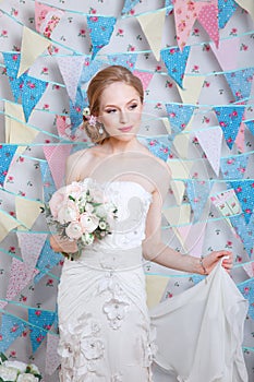 Bride.Young fashion model with make up, ,curly hair, flowers in hair. Bride fashion. Jewelry and Beauty. Woman in white dress