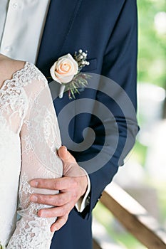 The bridegroom embraces the bride`s shoulder