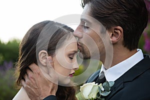 Bridegroom kissing on bride forehead