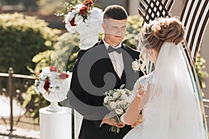 Brides and grooms stand by the golden arch during the painting ceremony