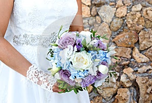Brides hands holding bridal bouquet close up